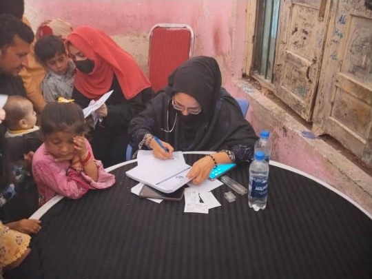 A lady doctor examining a mother and child at a free medical camp held by Ahmed Hospital
